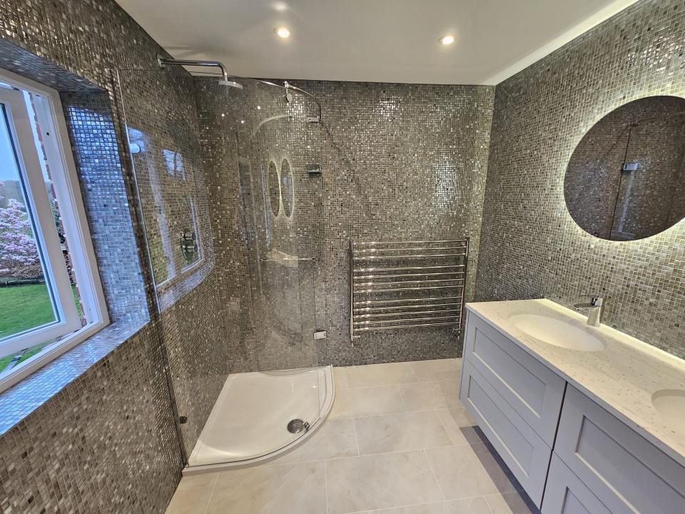 Mosaic-tiled shower with modern double sink vanity