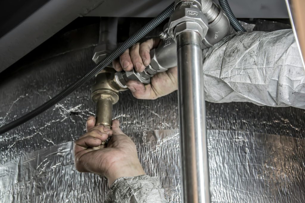 Plumbing work being done on metal pipes